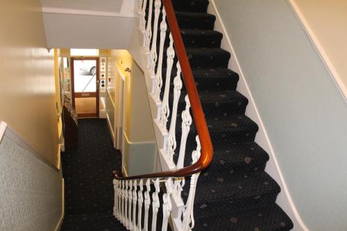 a winding staircase with black and white treads at Melbourne House Hotel in London