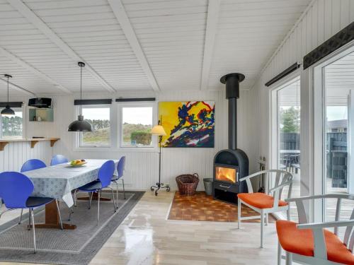 une salle à manger avec une table, des chaises et une cheminée dans l'établissement Holiday Home Mads - 950m from the sea in NW Jutland by Interhome, à Torsted