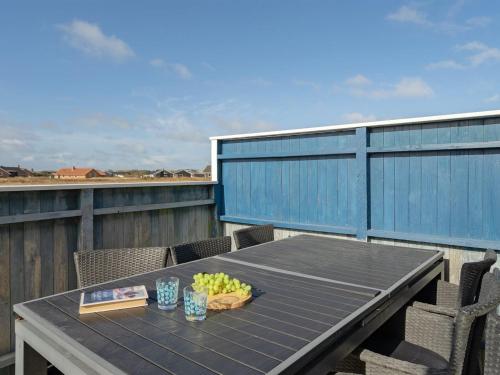 a table with a bowl of fruit on a balcony at Holiday Home Soyala - 400m from the sea in Western Jutland by Interhome in Harboør