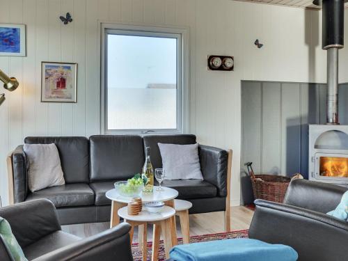 a living room with leather couches and a table at Holiday Home Soyala - 400m from the sea in Western Jutland by Interhome in Harboør