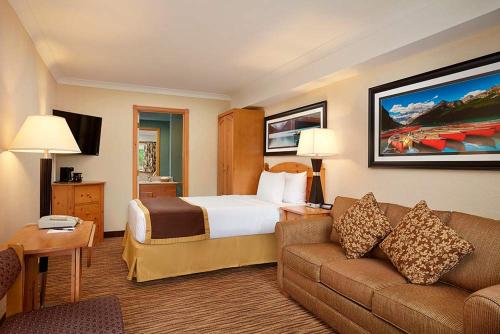 une chambre d'hôtel avec un lit et un canapé dans l'établissement Lake Louise Inn, à Lake Louise