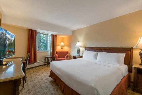 a hotel room with a large bed and a desk at Lake Louise Inn in Lake Louise