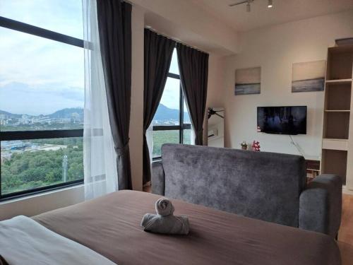 1 dormitorio con cama, sofá y ventanas grandes en Best Moments Studio City - Imperium Residence en Kuantan