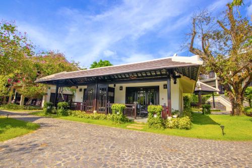 a house with a porch and a driveway at Anja Beach Resort & Spa in Phu Quoc