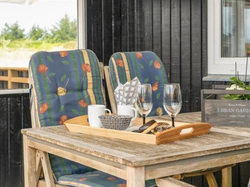 - une table avec deux chaises et un plateau en bois avec des verres à vin dans l'établissement Holiday Home Ivar - 900m from the sea in NW Jutland by Interhome, à Torsted