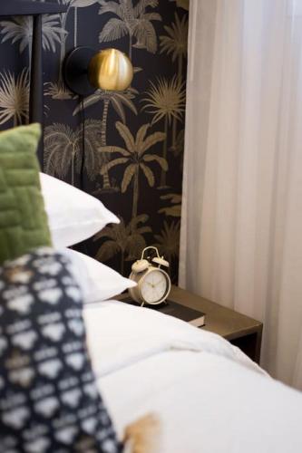 a bedroom with a bed and a clock on a table at Palms Little Italy Studio with full bathroom by Denstays in Montréal