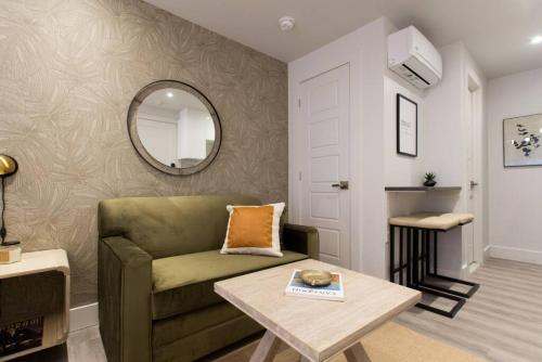 a living room with a green couch and a table at Palms Little Italy Studio with full bathroom by Denstays in Montréal