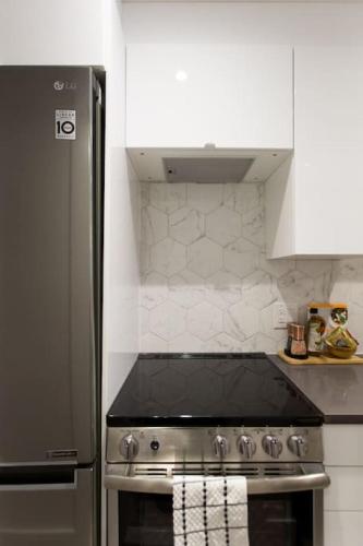 a kitchen with a stove and a refrigerator at Palms Little Italy Studio with full bathroom by Denstays in Montréal