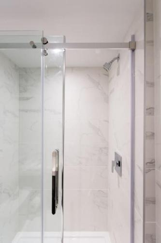 a shower with a glass door in a bathroom at Palms Little Italy Studio with full bathroom by Denstays in Montréal