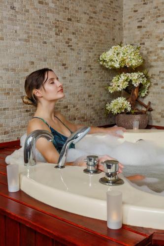 a woman is sitting in a bath tub at Optimum Luxury Hotel&Spa in Antalya