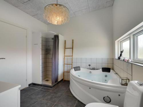 uma casa de banho com uma banheira, um chuveiro e um WC. em Holiday Home Julika - 400m from the sea in NW Jutland by Interhome em Torsted