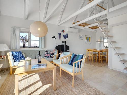 ein Wohnzimmer mit einem Tisch und Stühlen in der Unterkunft Holiday Home Tabea - 150m from the sea in NW Jutland by Interhome in Løkken