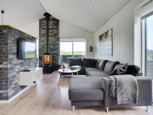 een woonkamer met een bank en een open haard bij Holiday Home Øthbiorn - 1-1km from the sea in NW Jutland by Interhome in Løkken