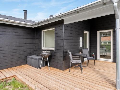 a patio with a table and chairs and a grill at Holiday Home Raakel - 950m from the sea by Interhome in Torsted