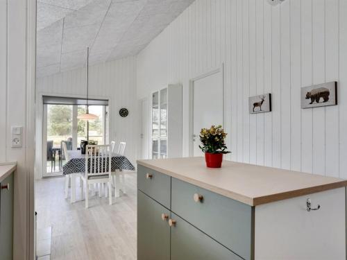 a kitchen with white walls and a table with flowers at Holiday Home Raakel - 950m from the sea by Interhome in Torsted