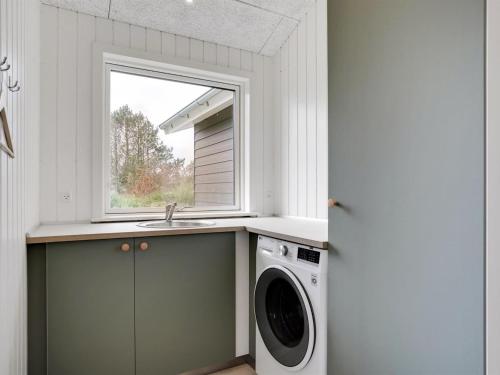 a laundry room with a sink and a washing machine at Holiday Home Raakel - 950m from the sea by Interhome in Torsted