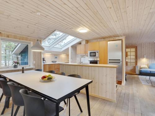 a kitchen and living room with a table and chairs at Holiday Home Anegrete - 900m from the sea in NW Jutland by Interhome in Torsted