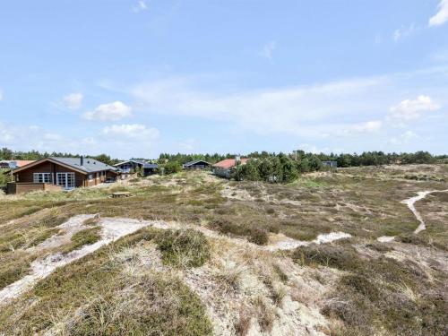 un campo de hierba con casas en el fondo en Holiday Home Eggerich - 900m from the sea in NW Jutland by Interhome, en Torsted