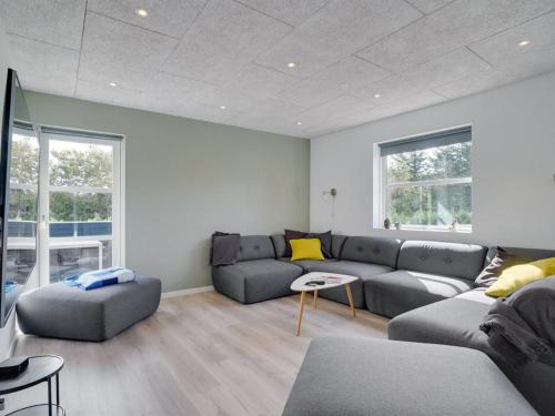 ein Wohnzimmer mit einem Sofa und einem Tisch in der Unterkunft Holiday Home Ingwio - 1-5km from the sea in NW Jutland by Interhome in Torsted