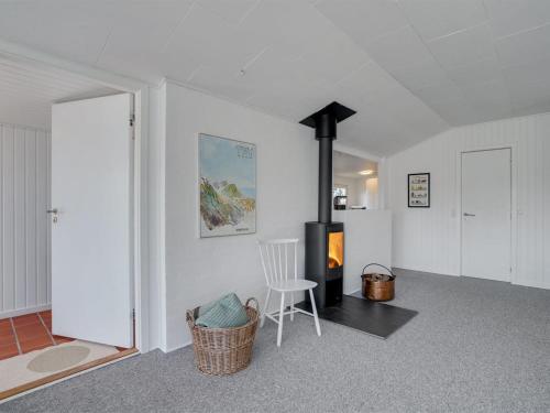 sala de estar con chimenea y silla en Holiday Home Kanerva - 350m from the sea in NW Jutland by Interhome, en Torsted