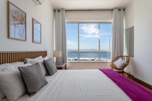 um quarto com uma cama e uma grande janela em Sofisticado em Copacabana - Vista para praia - A403 Z3 no Rio de Janeiro
