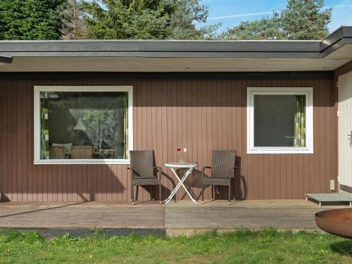 een patio met 2 stoelen en een tafel op een huis bij Holiday Home Fot - 7km from the sea in Djursland and Mols by Interhome in Ebeltoft