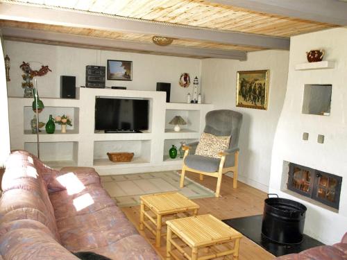 uma sala de estar com um sofá e uma televisão em Holiday Home Genta - 100m from the sea in NW Jutland by Interhome em Lokken