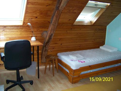 a bedroom with a bed and a desk and a chair at La Salamandre in Écouflant