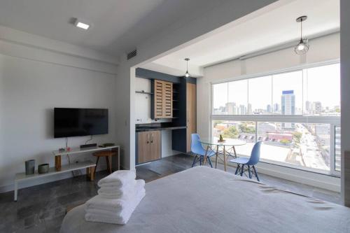 a bedroom with a bed and a television and a table at Contemporary Studio - GRU in Guarulhos