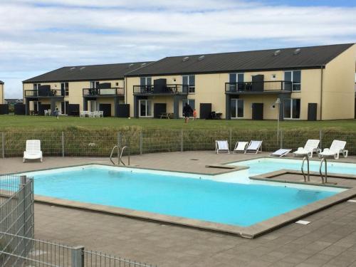 uma grande piscina em frente a uma casa em Apartment Tomte - 70m from the sea in NW Jutland by Interhome em Lokken