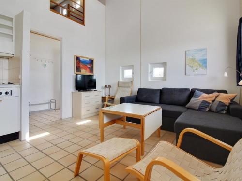 uma sala de estar com um sofá e uma mesa em Apartment Tomte - 70m from the sea in NW Jutland by Interhome em Lokken
