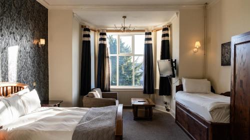 a hotel room with two beds and a window at The Heworth Inn in York