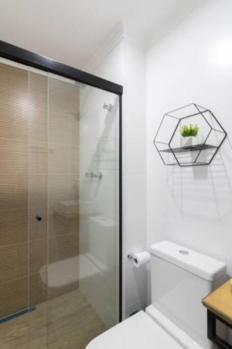 a bathroom with a toilet and a glass shower at Contemporary Studio - GRU 1103 in Guarulhos