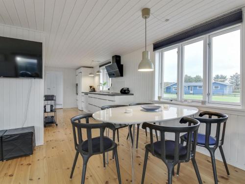 a kitchen and dining room with a white table and chairs at Holiday Home Nehat - 300m from the sea in NW Jutland by Interhome in Løkken