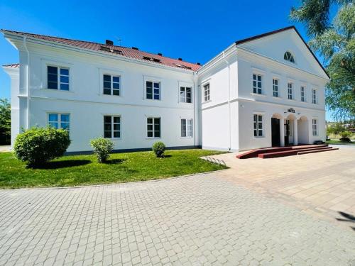 duży biały dom z dużym podjazdem w obiekcie Nad Starą Nidą *** w mieście Pińczów