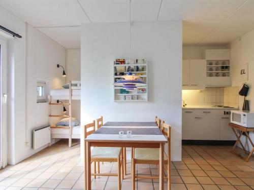 uma cozinha e sala de jantar com mesa e cadeiras em Apartment Tinke - 150m from the sea in NW Jutland by Interhome em Lokken