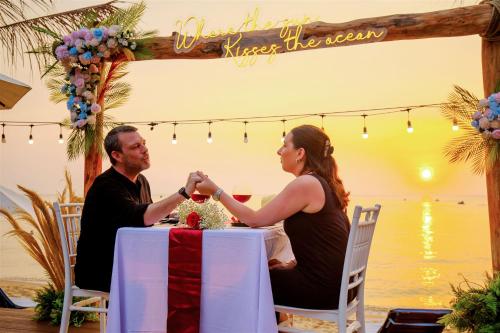 a man and a woman are sitting at a table at Anja Beach Resort & Spa in Phu Quoc