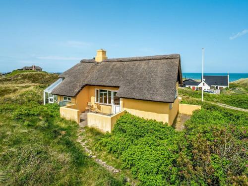 uma casa numa colina com o oceano ao fundo em Holiday Home Quirina - 75m from the sea in NW Jutland by Interhome em Torsted