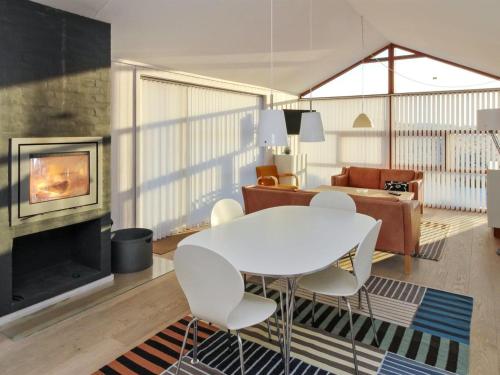 sala de estar con mesa blanca y sillas en Holiday Home Erko - 150m from the sea in NW Jutland by Interhome, en Løkken