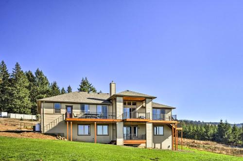 a large house on top of a grassy hill at Chic Willamette Valley Home with Deck and Vineyard! in Gaston