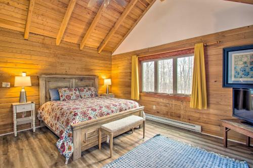 Wintergreen的住宿－Wintergreen Home with Deck - Near Skiing and Hiking!，一间卧室设有木墙、一张床和电视。