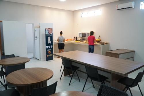 2 personnes dans une cuisine avec des tables et un comptoir dans l'établissement Honório pousada - Tucano BA, à Tucano