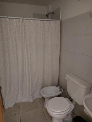 a bathroom with a toilet and a shower curtain at Departamento centrico in San Luis