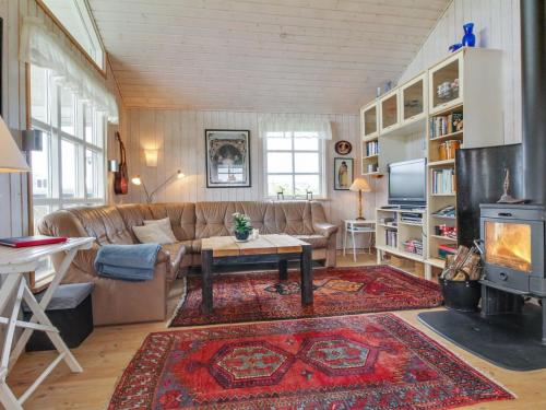 een woonkamer met een bank en een tafel bij Holiday Home Jerker - 400m from the sea in NW Jutland by Interhome in Løkken