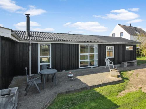 a house with a patio with a table and chairs at Holiday Home Fabio - 450m from the sea in NW Jutland by Interhome in Løkken