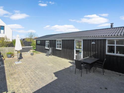 a patio with a table and chairs and a building at Holiday Home Fabio - 450m from the sea in NW Jutland by Interhome in Løkken