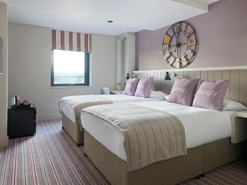 a bedroom with a large bed and a large window at Village Hotel Edinburgh in Edinburgh