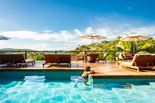 uma mulher na piscina de um resort em Jubarte Hotel by Insólito em Búzios