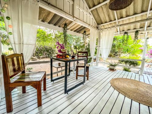 a room with a table and chairs on a porch at Villa Wonderworld Resort in Ban Nua