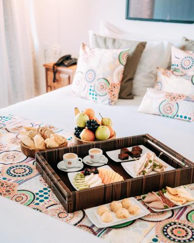 a tray of food on top of a bed at Jubarte Hotel by Insólito in Búzios